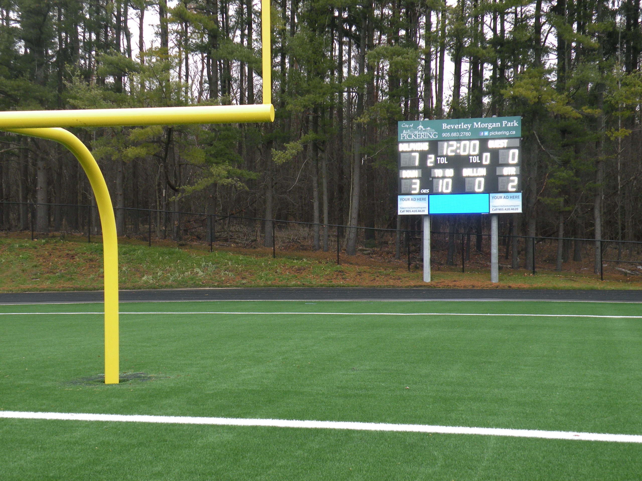 Football goal posts, with score board in background.