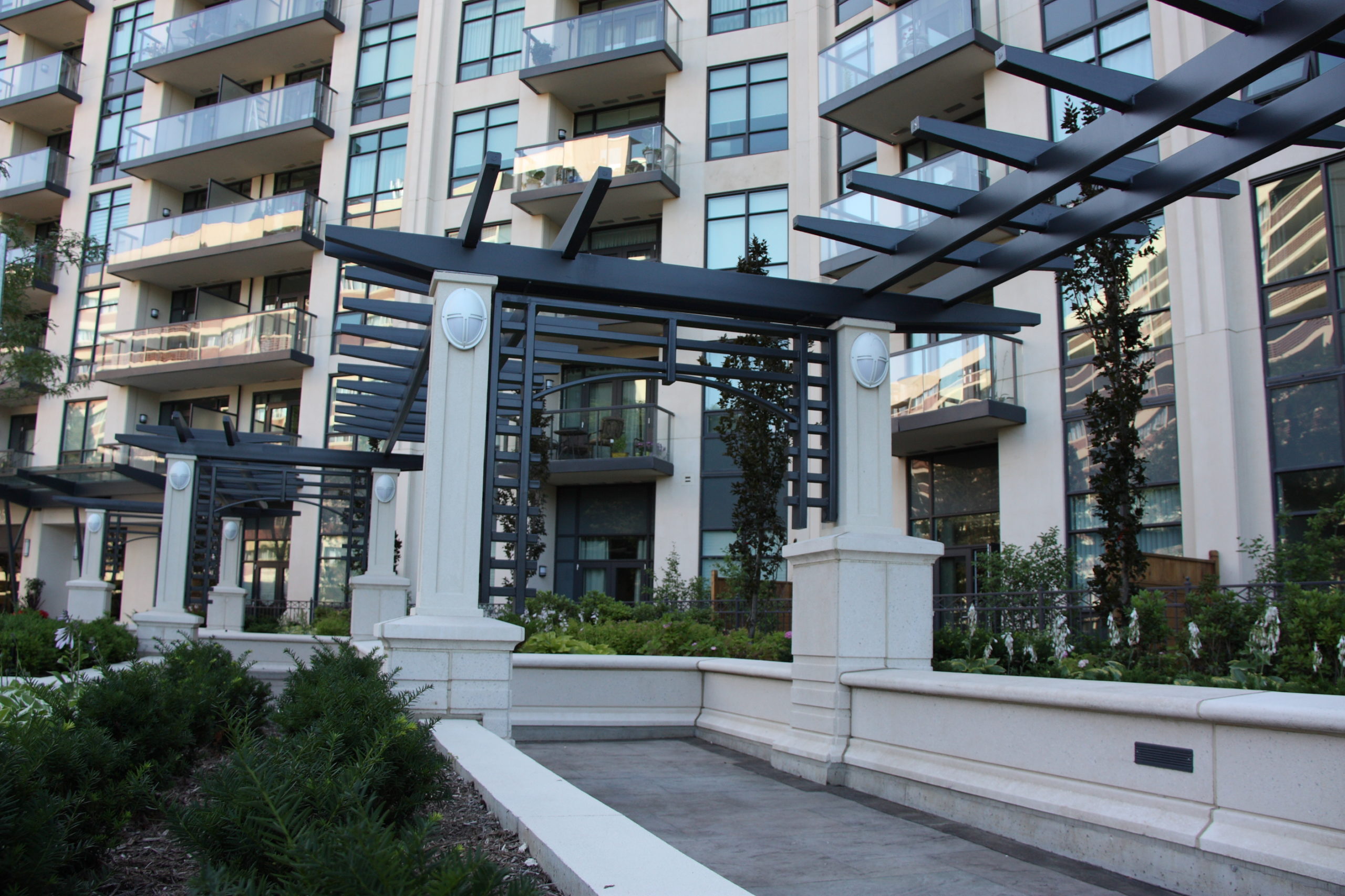 Monolithic, meandering garden trellis and seat walls defining the arrival plaza