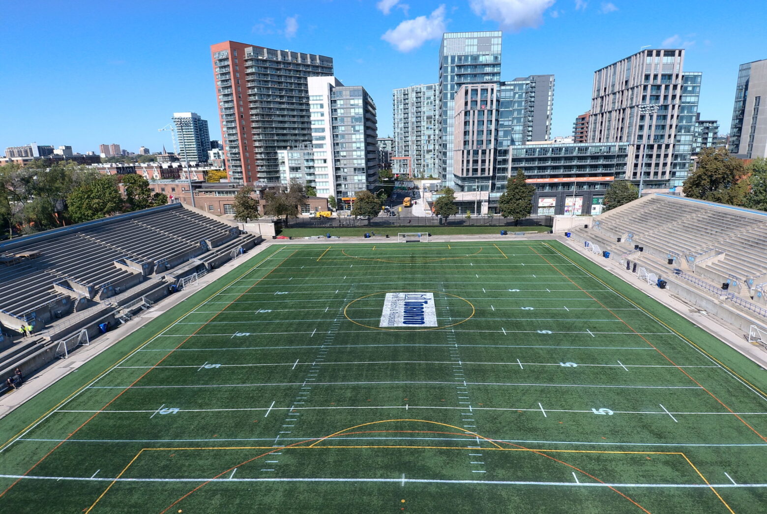 Birds eye view of soccer field with buildings in the background.