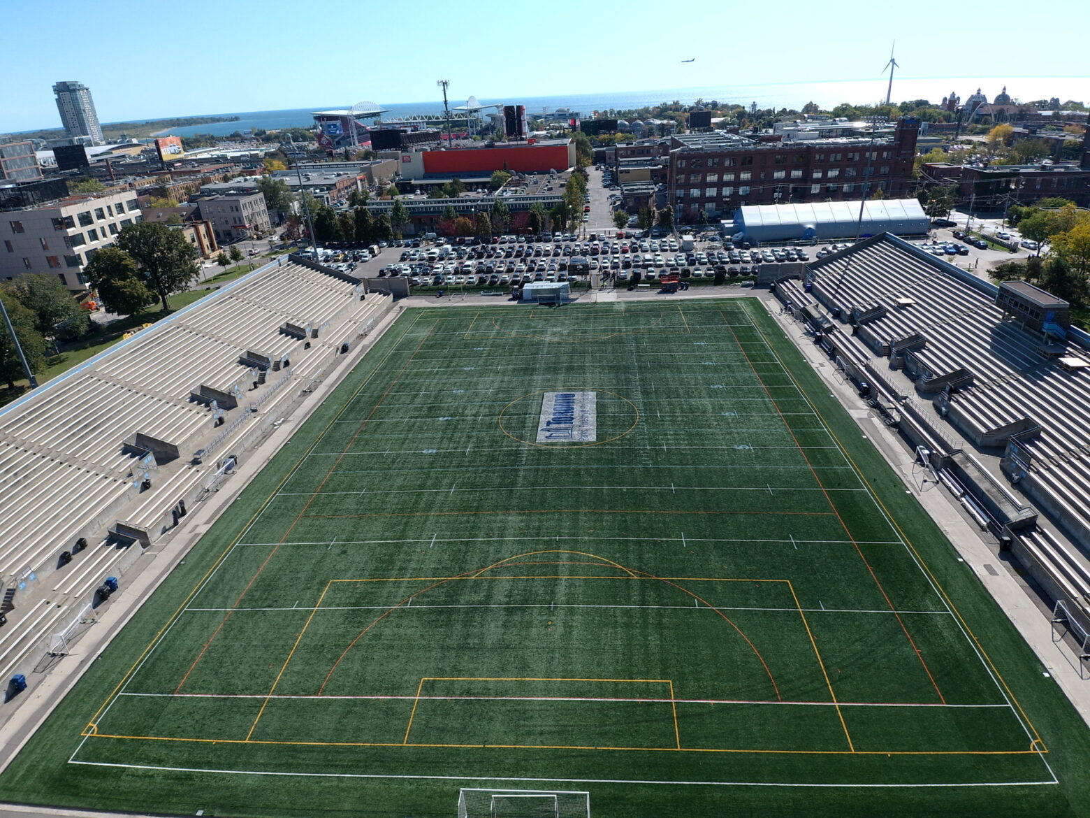 Birds eye view of soccer field with buildings in the background.