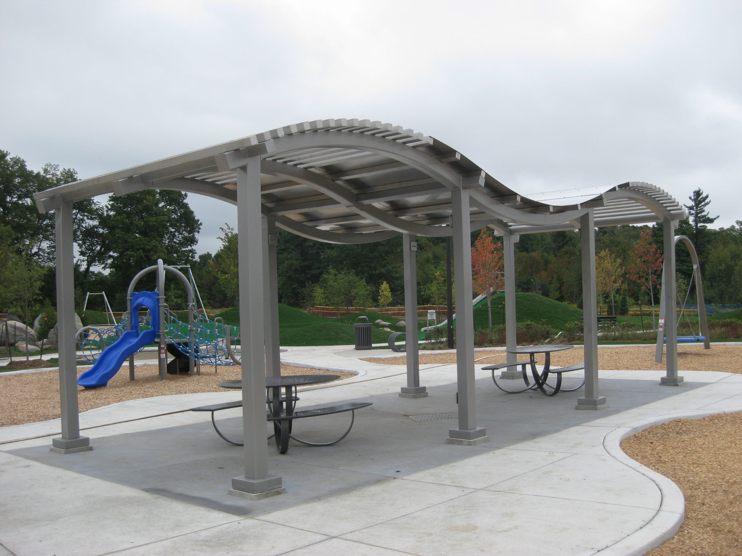 Shade structure with picnic benches under it.