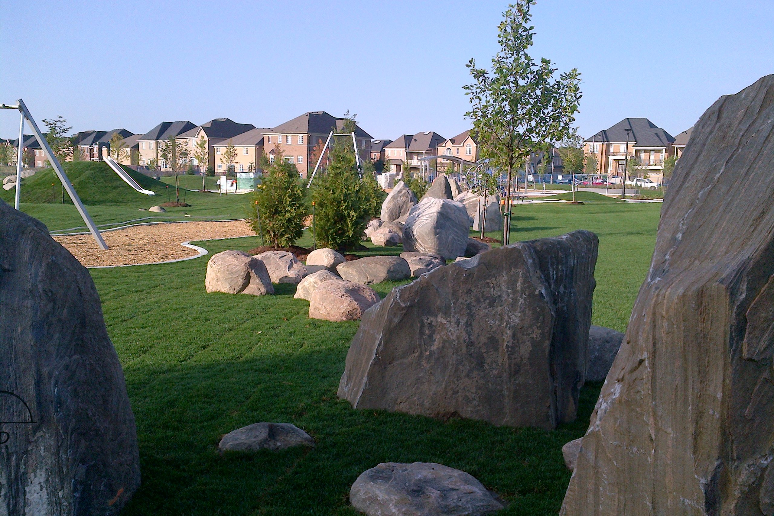 Large rocks with playground in background.