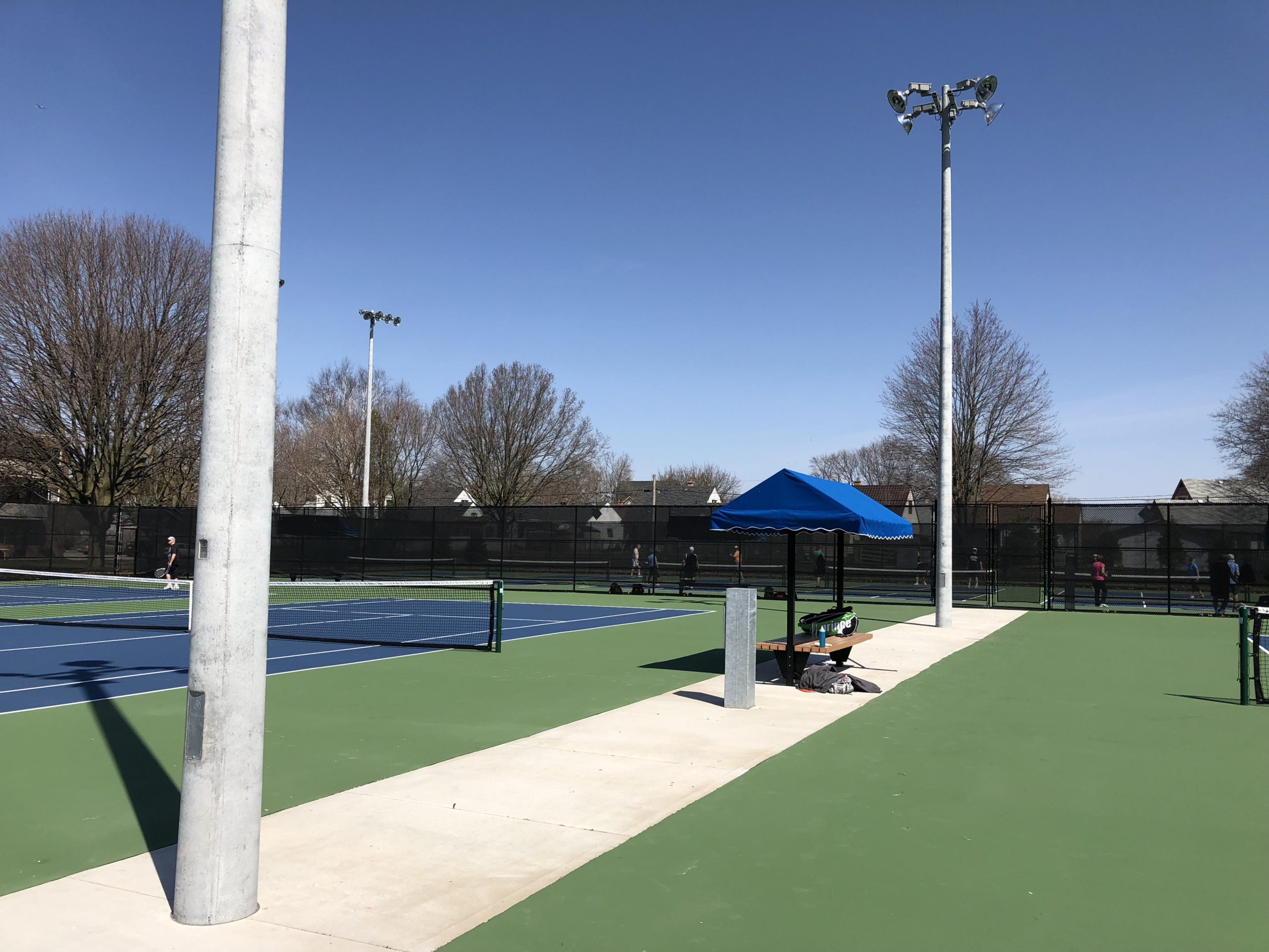 Shaded bench beside a tennis court