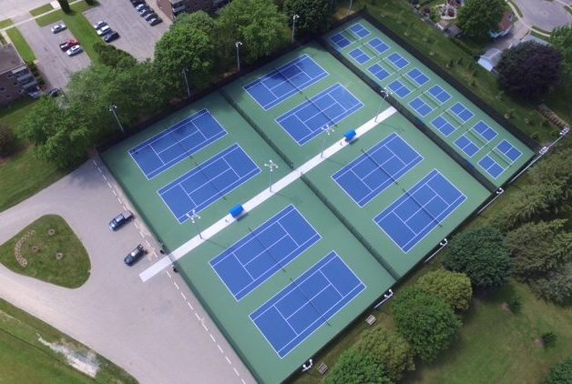 Birds eye view of multiple tennis courts.