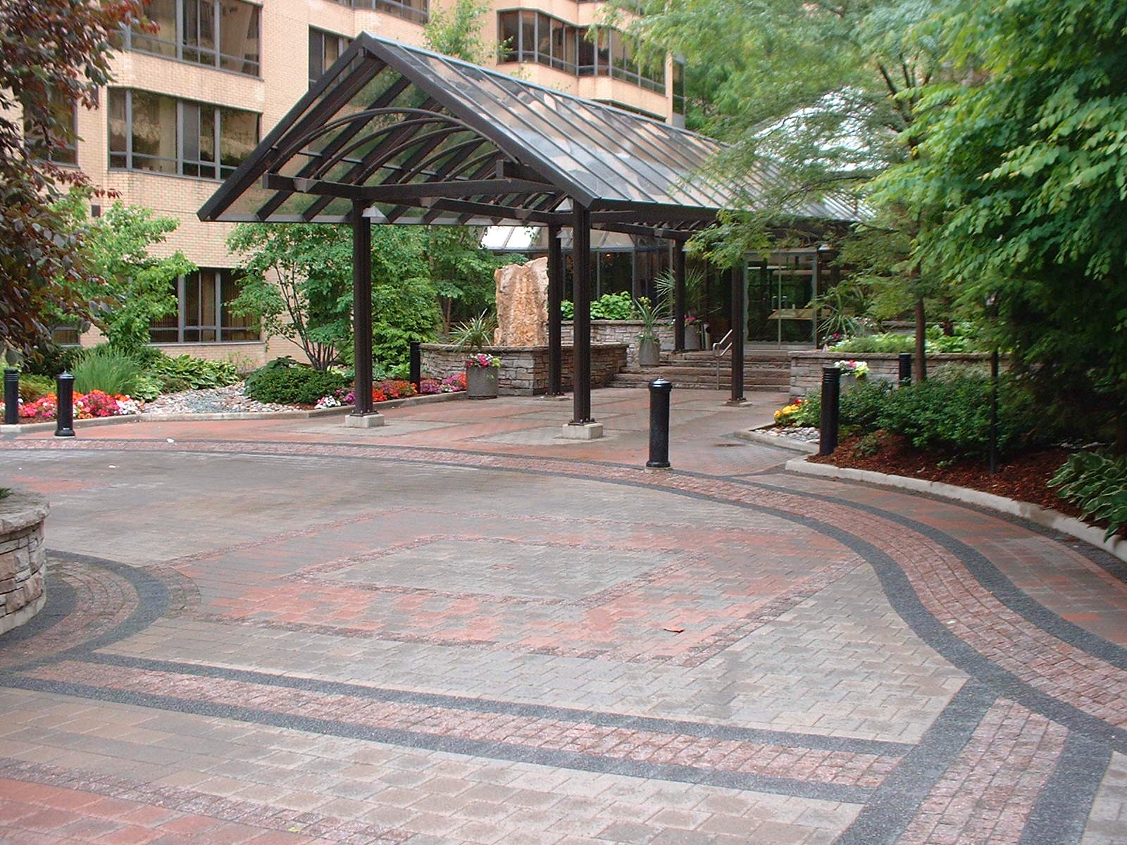 Covered entrance with trees and plants on either side.